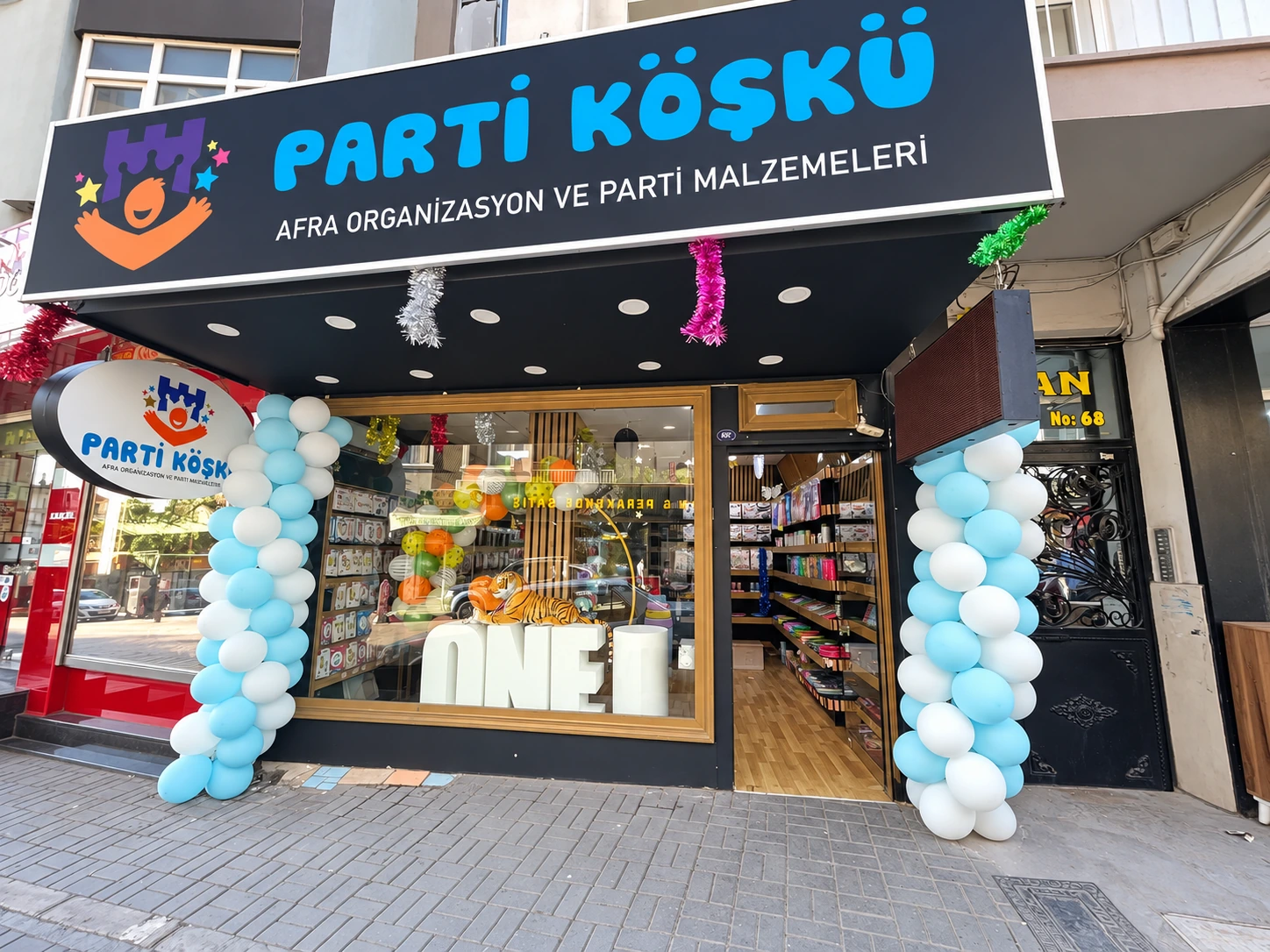 Parti Köşkü’nün gerçek mağaza cephesi, tabelası ve açık mavi beyaz balonlarla süslü girişi