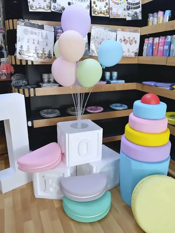 Parti Köşkü mağazasında pastel renkli kutlama dekorları, balonlar ve farklı boyutlarda sunum yükseltileri